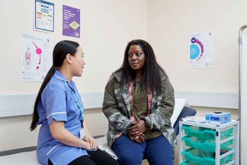 Photo showing a nurse speaking to a patient about cervical screening.